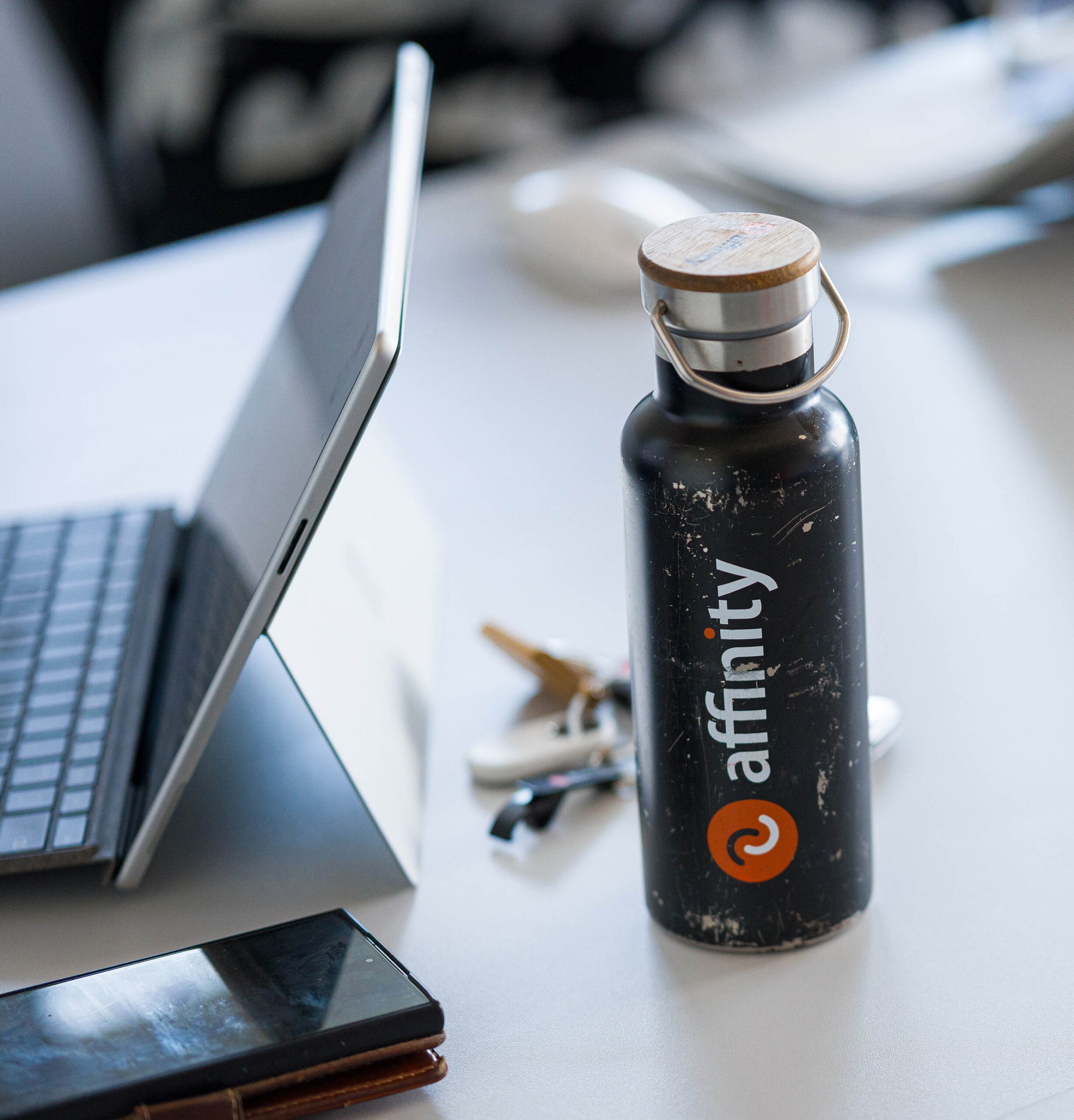 Laptop and Affinity water bottle on desk